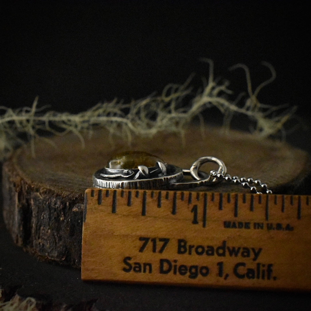The side of the Real Moss Shadow Box Forest Floor Pendant with a ruler for scale, measuring around 1 1/8 inches long.