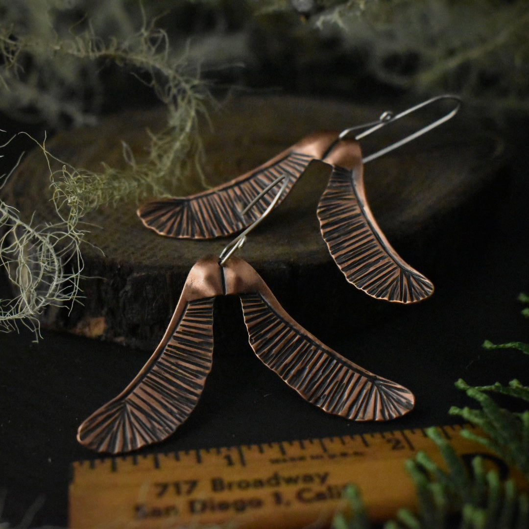 The Big Helicopter Earrings with a ruler for scale, each measuring around 2 1/8 inches wide.