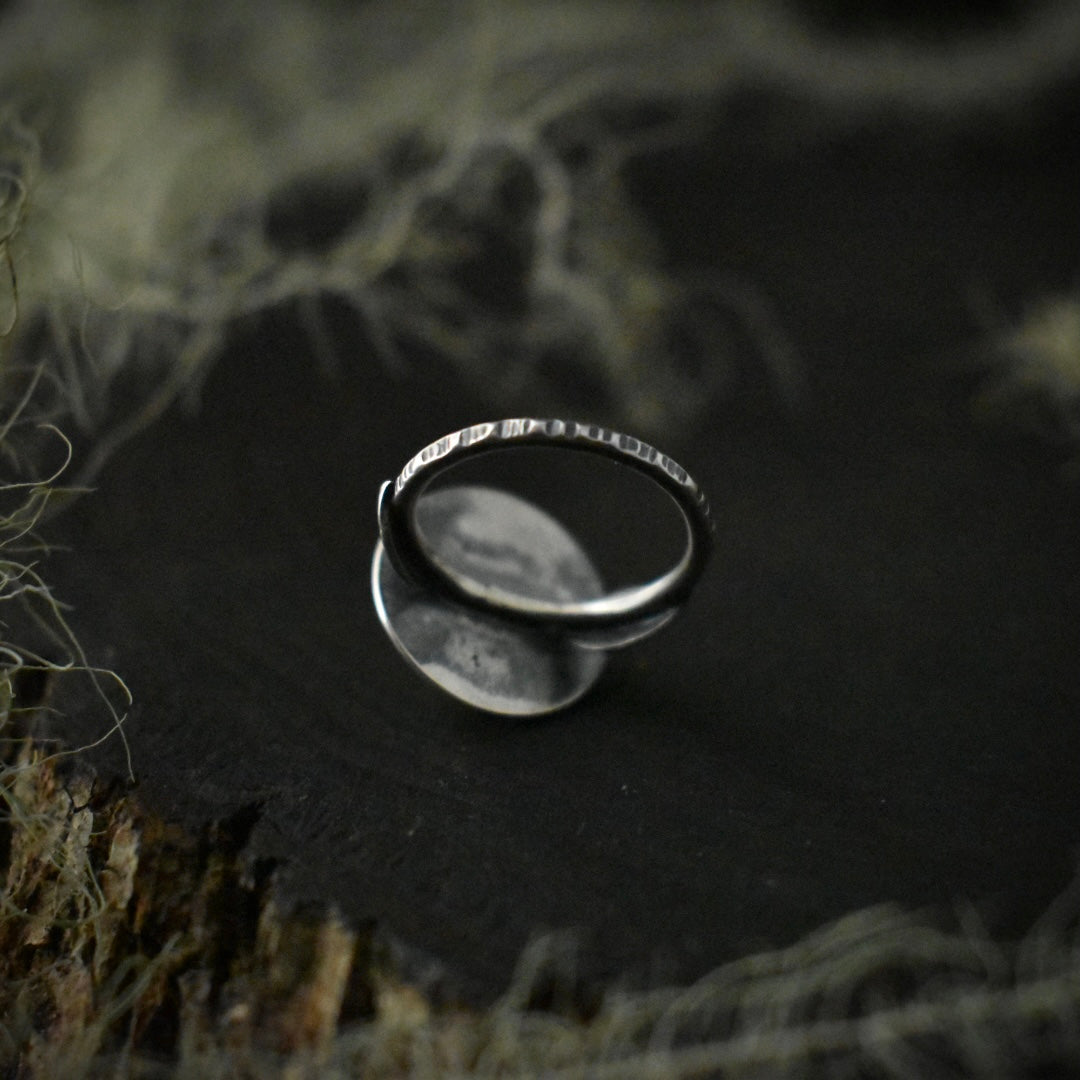 The underside of the Real Lichen Classic Double Leaf Ring, showing its size 5 1/2 sterling silver ring band, textured to look like tree bark.