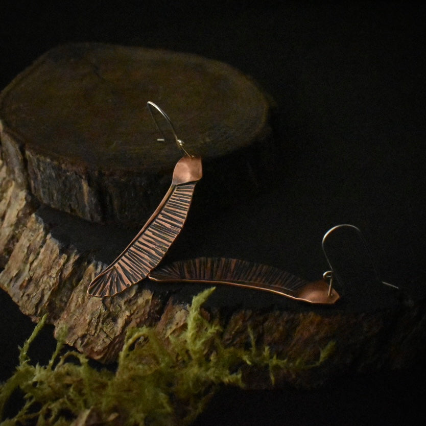 Another look at the Single Helicopter Earrings, showing their sterling silver ear wires.