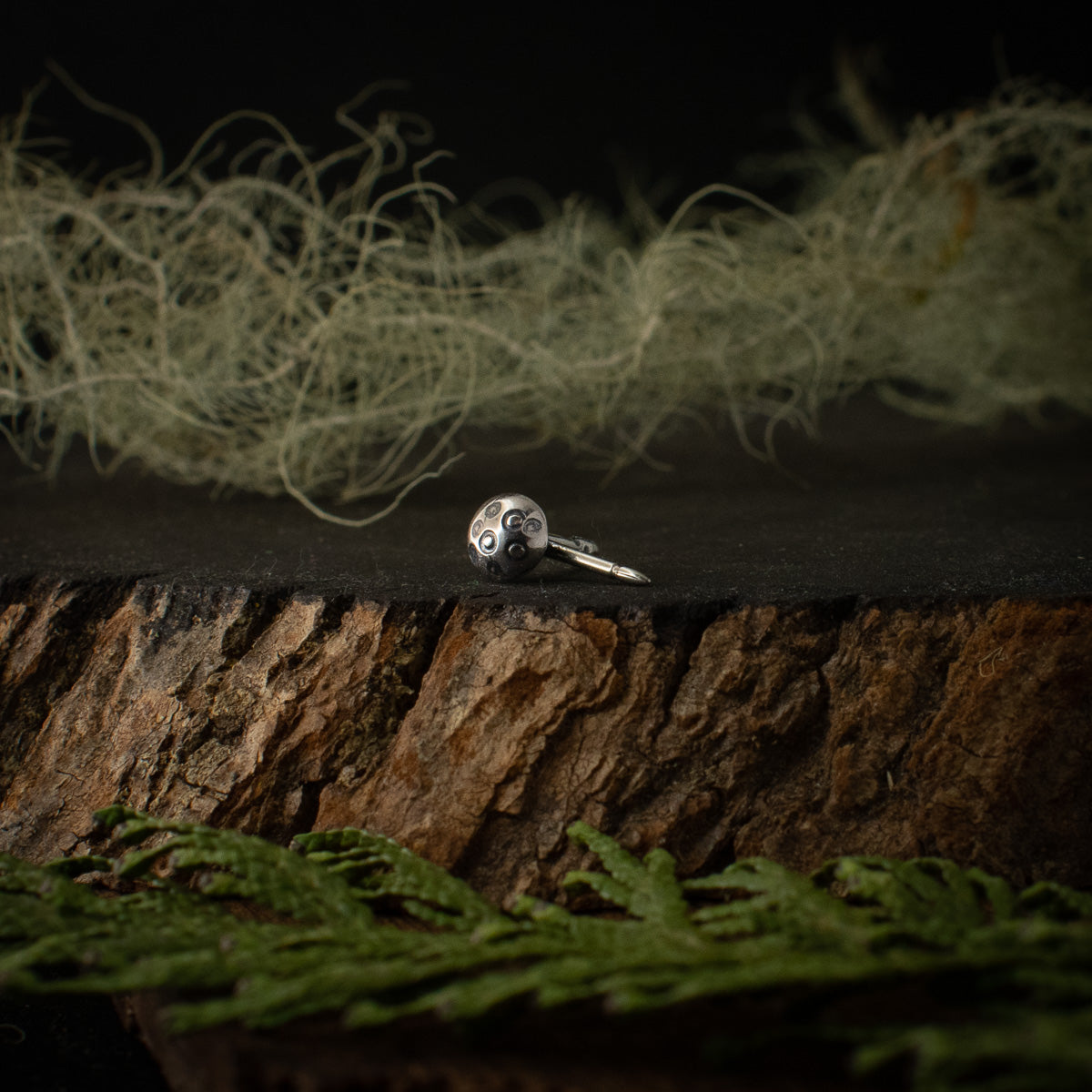 Another look at the Amanita Lapel Pin, showing the details of its sterling silver mushroom cap and its nickel pin stem.