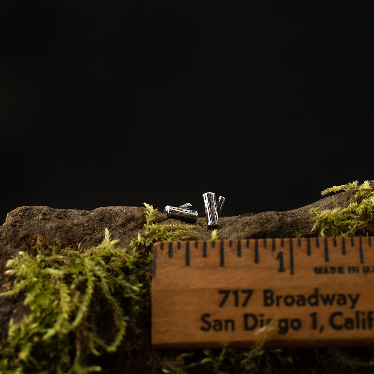 The Little Log Studs with a ruler for scale, each measuring around 1/8 inch wide and 1/4 inch long overall.