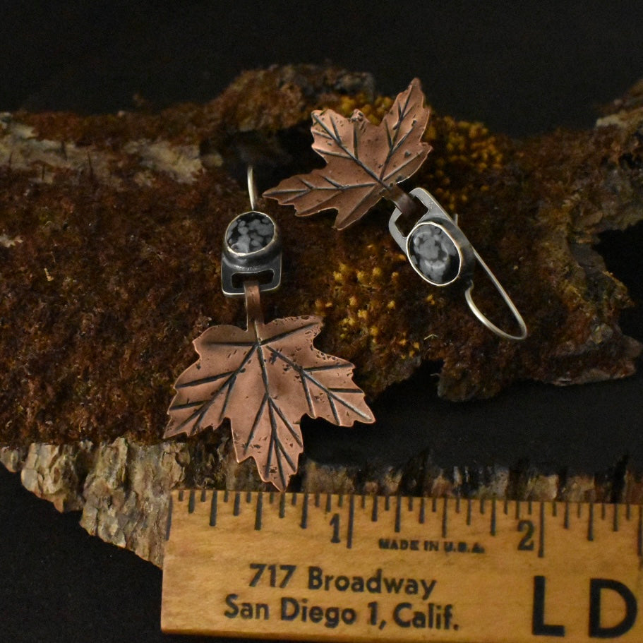 The Snowflake Obsidian Maple Leaf Earrings with a ruler for scale, each measuring around 1 1/4 inches wide.