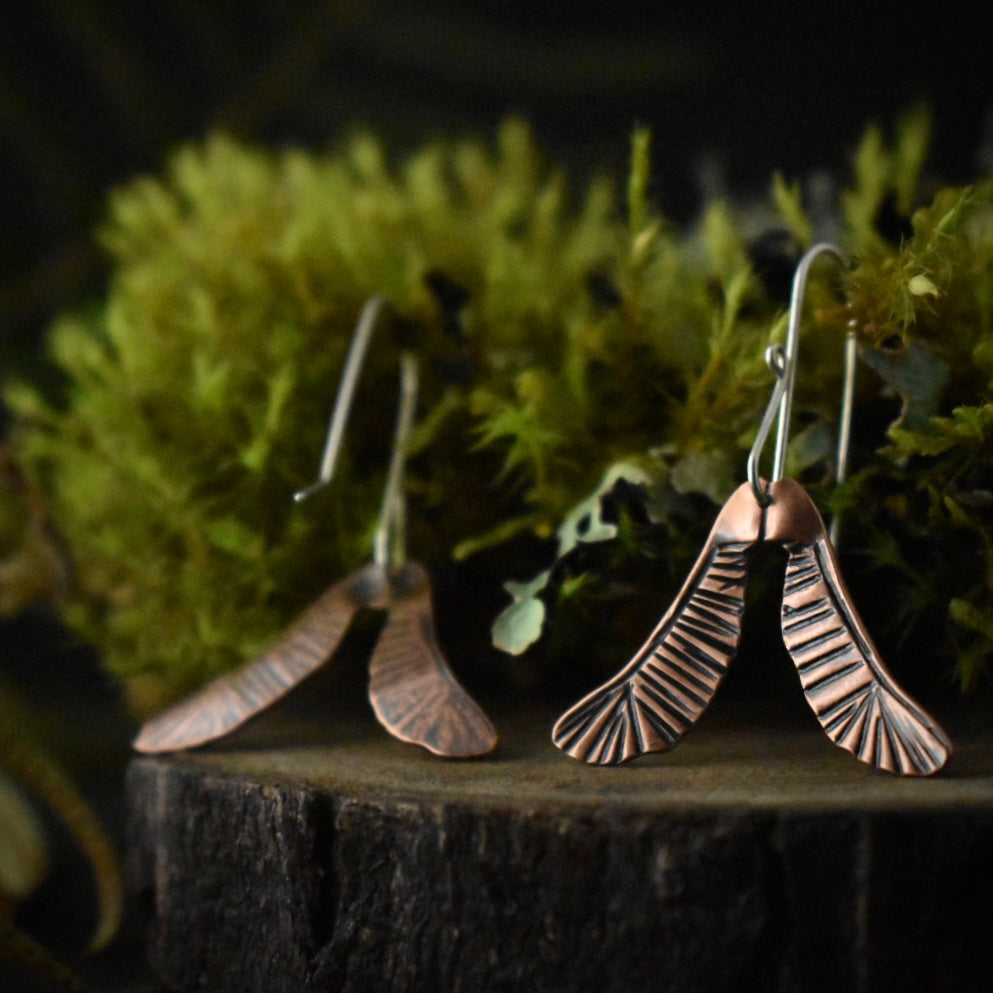 Another look at the Copper Helicopter Earrings, one is earring is flipped over.