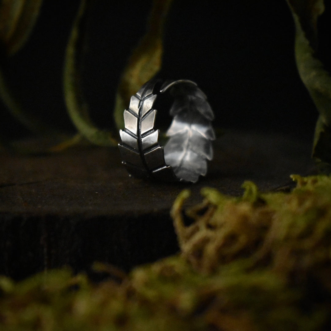 A handmade sterling silver band ring, stamped and textured to look like part of a pot leaf.