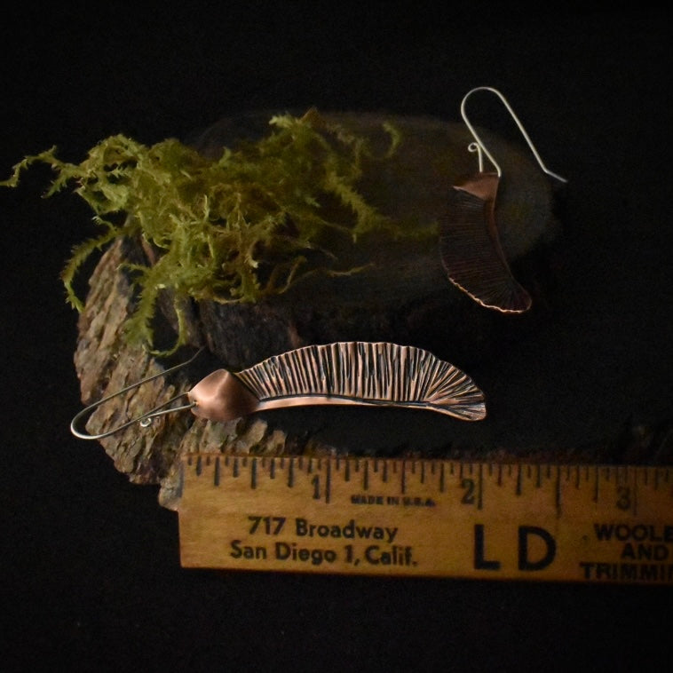 The Big Single Helicopter Earrings with a ruler for scale, each measuring around 2 inches long, not including its sterling silver ear wire.
