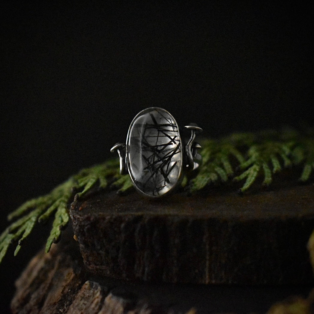 A handmade sterling silver statement ring, with a setting of clear quartz streaked by black, needle-shaped inclusions.