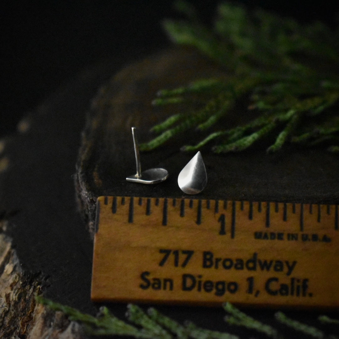 The Raindrop Stud Earrings with a ruler for scale, each measuring around 1/4 inch wide.
