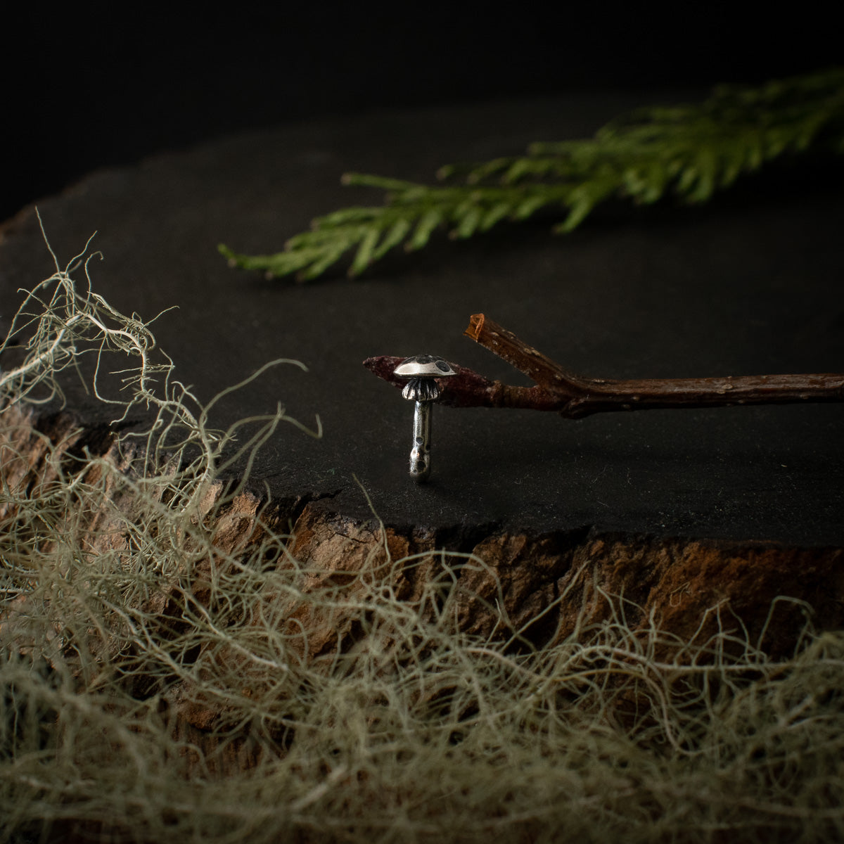 A handmade sterling silver pin, formed and textured to look like an amanita mushroom.