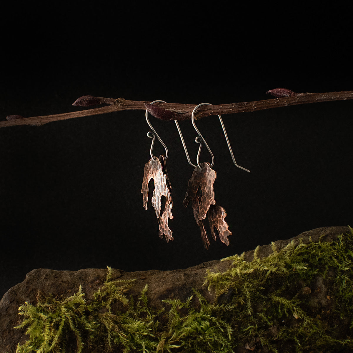 The pair of Copper Layered Lichen Earrings viewed from the side, dangling by their sterling silver ear wires.