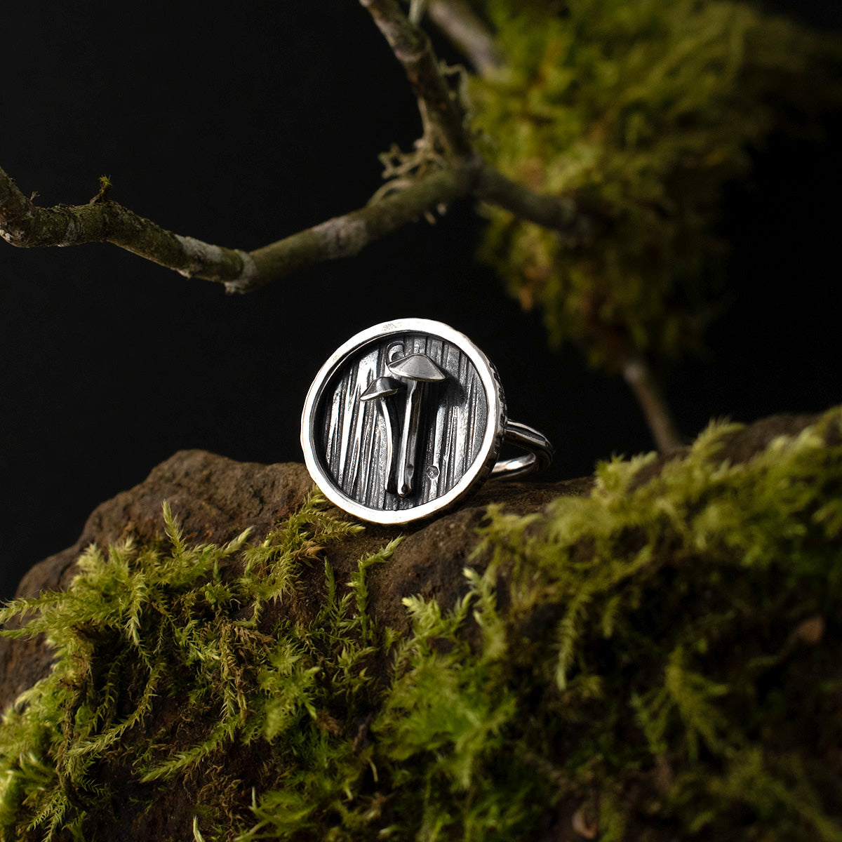 A handmade sterling silver statement ring, a dramatic shadow box setting encircles two miniature Mycena, all atop a rounded band, textured by hand like tree bark.