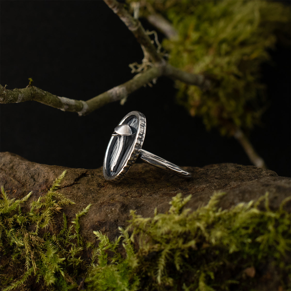 The left side of the Mycena Duo Shadow Box Ring, showing the depth of its bark-textured sterling silver shadow box, and the structure of its two fungi.