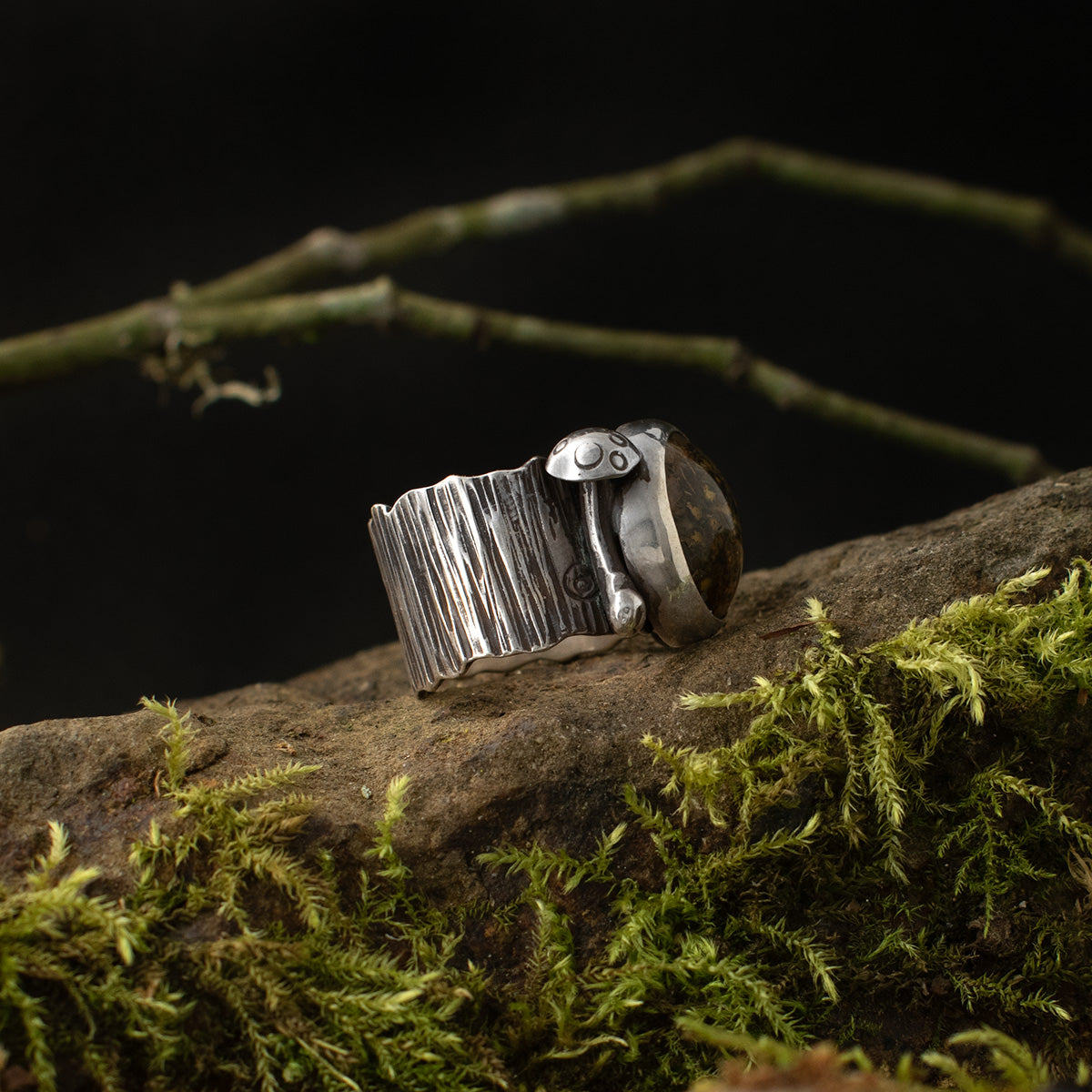 The left side of the Real Lichen Double Toadstool Ring shows one of its sterling silver mushrooms and its vividly patinated bark band.